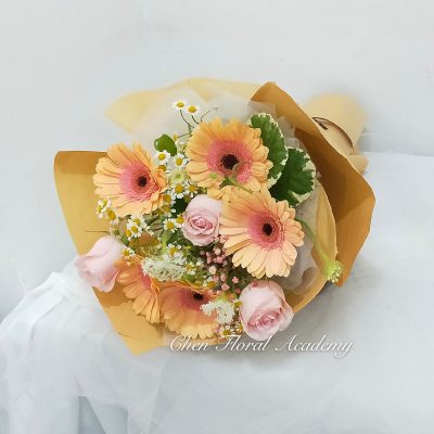 pink gerbera & pink roses in light brown wrapping