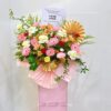 Business Opening stand with pink,red & light yellow flowers and gold deco fans