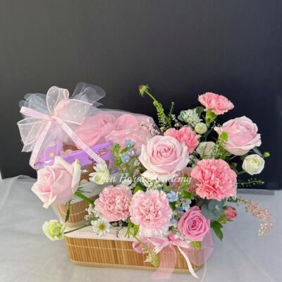 New born flower basket gift with pink flowers and baby products