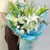 white lilies & other white color seasonal side fillers in light blue wrapping